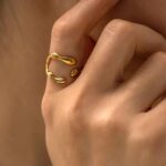 Bague organique en acier inoxydable doré avec design fluide et ouvert