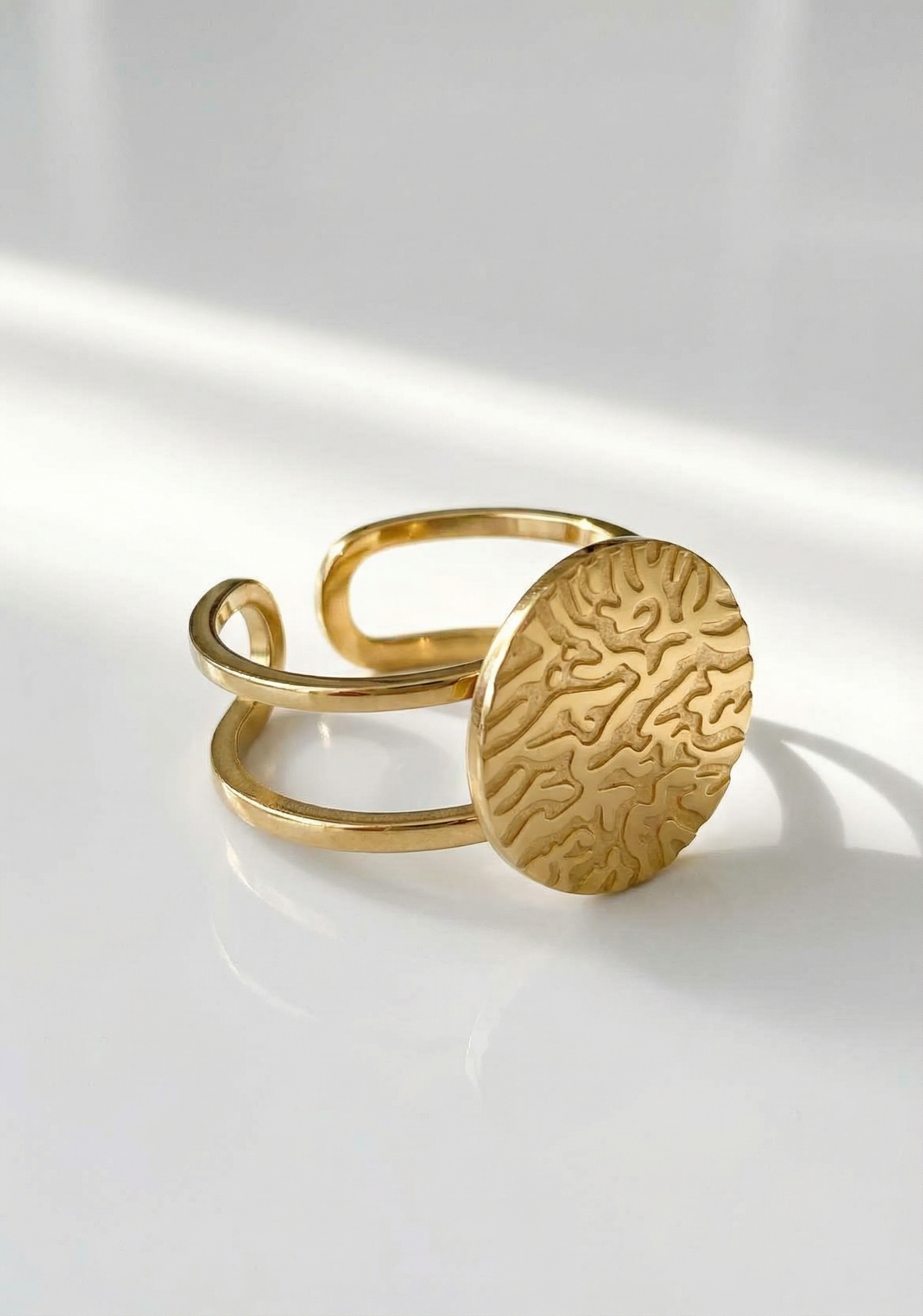 Bague ouverte dorée avec disque texturé au design organique