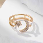 Bague ouverte dorée avec étoile scintillante, lune ornée de pierres et perles délicates