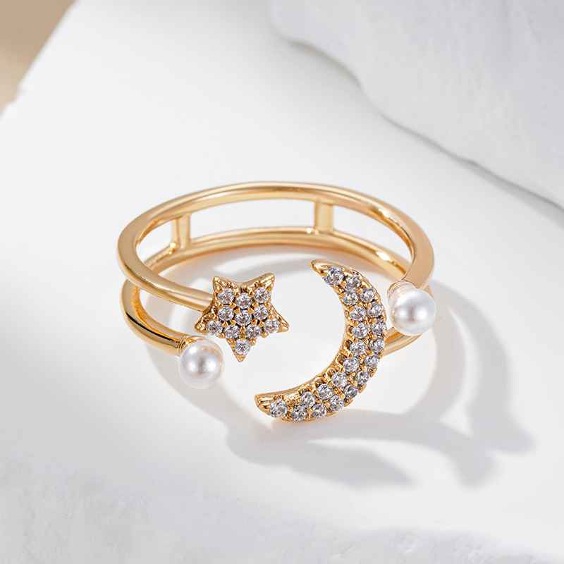 Bague ouverte dorée avec étoile scintillante, lune ornée de pierres et perles délicates