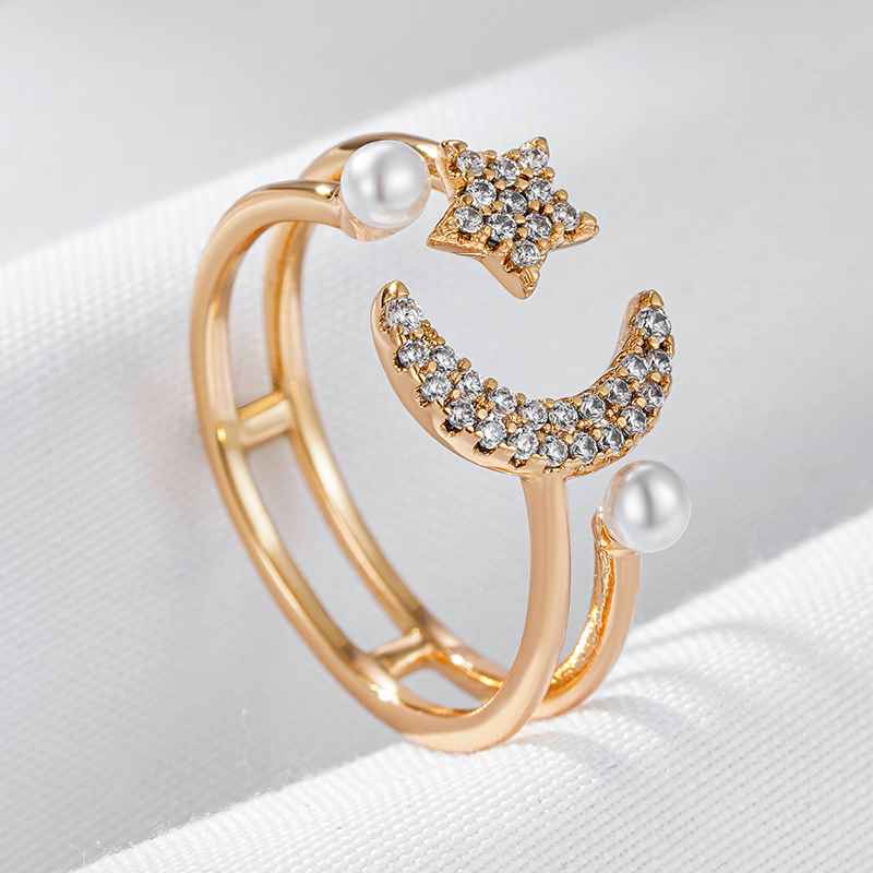 Bague ouverte dorée avec étoile scintillante, lune ornée de pierres et perles délicates