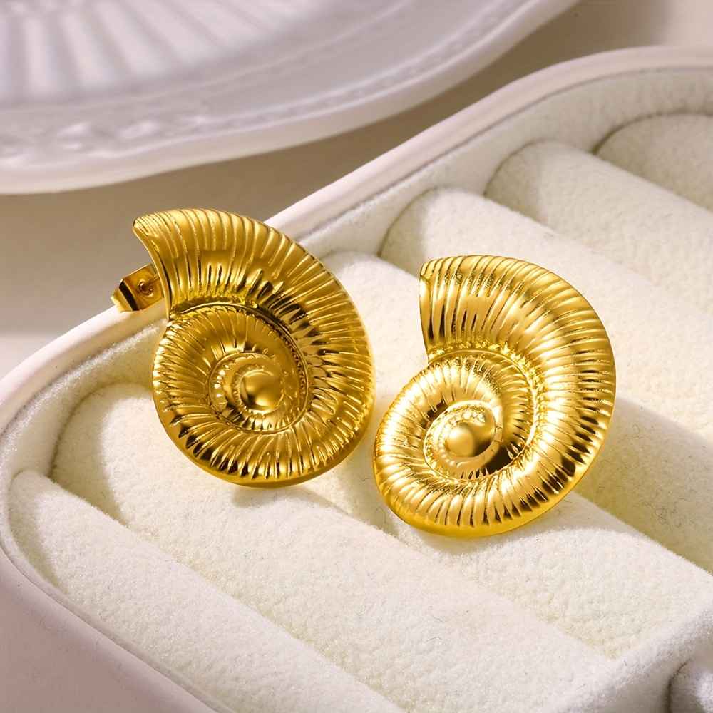 boucles-oreilles-acier-inoxydable-spirale.jpg (3) Photo de boucles d'oreilles en spirale dorée, fabriquées en acier inoxydable, présentées dans un écrin en velours blanc.