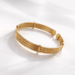 Bracelet manchette doré avec design texturé et barres décoratives