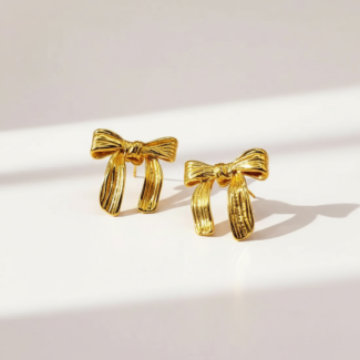 Photo de boucles d'oreilles dorées en forme de nœud, fabriquées en acier inoxydable, sur fond blanc.