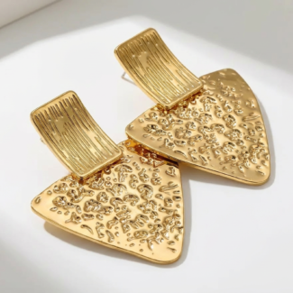 Photo de boucles d'oreilles dorées en forme triangulaire avec une texture martelée, fabriquées en acier inoxydable, sur fond blanc.